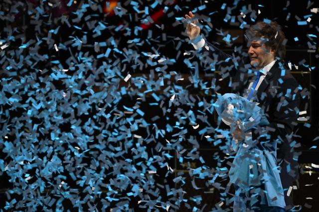 Argentina's President Javier Milei waves to supporters during the launch of his new book, "The Making of the Miracle," at the Movistar Arena in Buenos Aires on October 6, 2025. (Photo by Luis ROBAYO / AFP)