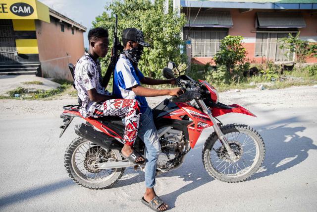 Armed gang members on a motorbike patrol the streets in the Mariani neighborhood of Port-au-Prince, Haiti, on October 6, 2025. Mariani is near the Route Nationale 2, parts of which have been taken over by gangs. More than 16,000 people have been killed in armed violence in Haiti since the start of 2022, the United Nations said on October 2, warning that "the worst may be yet to come". The poorest country in the Americas, Haiti has long suffered at the hands of violent criminal gangs that commit murders, rapes, looting, and kidnappings against a backdrop of chronic political instability. (Photo by Clarens SIFFROY / AFP)