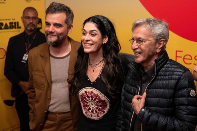 Brazilian musician Caetano Veloso (R), his wife Paula Lavigne (C) and actor Wagner Moura (R) pose for a photo at the gala premiere of the film "O Agente Secreto" (The Secret Agent) during the 27th Rio Film Festival at Cinema Odeon in Rio de Janeiro, Brazil on October 7, 2025. (Photo by Pablo PORCIUNCULA / AFP)