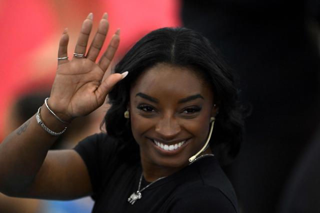 US Olympic gymnast Simone Biles waves during a gymnastics clinic at the Mary Teran de Weiss Stadium in Buenos Aires on October 9, 2025. (Photo by LUIS ROBAYO / AFP)