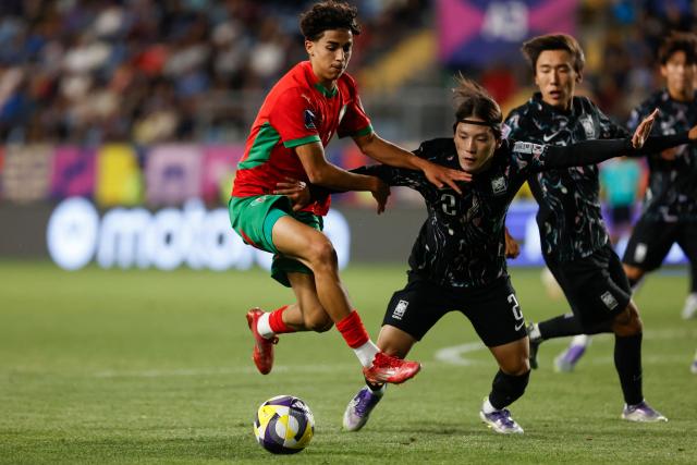 Morocco's midfielder #10 Saad El Haddad and South Korea's defender #02 Hyunseo Bae fight for the ball during the 2025 FIFA U-20 World Cup round of 16 football match between Morocco and South Korea at El Teniente Stadium in Rancagua, Chile on October 9, 2025. (Photo by Raul BRAVO / AFP)