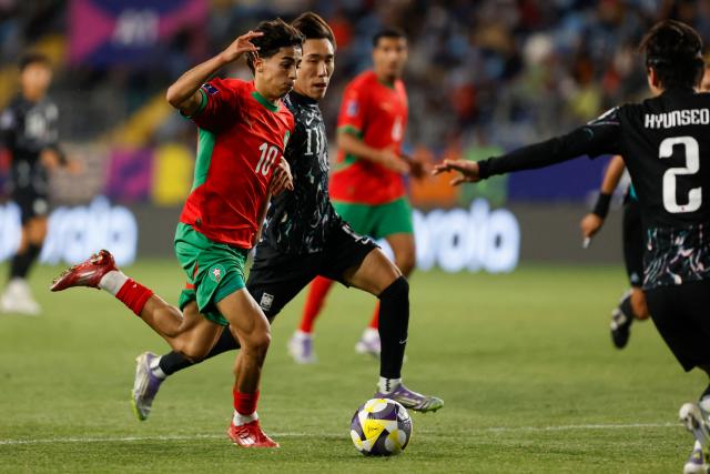 Morocco's midfielder #10 Saad El Haddad and South Korea's forward #11 Myeongjun Kim fight for the ball during the 2025 FIFA U-20 World Cup round of 16 football match between Morocco and South Korea at El Teniente Stadium in Rancagua, Chile on October 9, 2025. (Photo by Raul BRAVO / AFP)