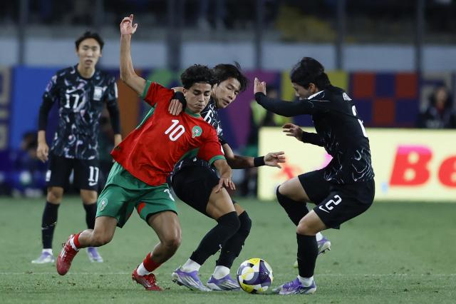 Morocco's midfielder #10 Saad El Haddad fights for the ball with South Korea's midfielder #06 Seungmin Son and defender #02 Hyunseo Baeduring the 2025 FIFA U-20 World Cup round of 16 football match between Morocco and South Korea at El Teniente Stadium in Rancagua, Chile on October 9, 2025. (Photo by Raul BRAVO / AFP)