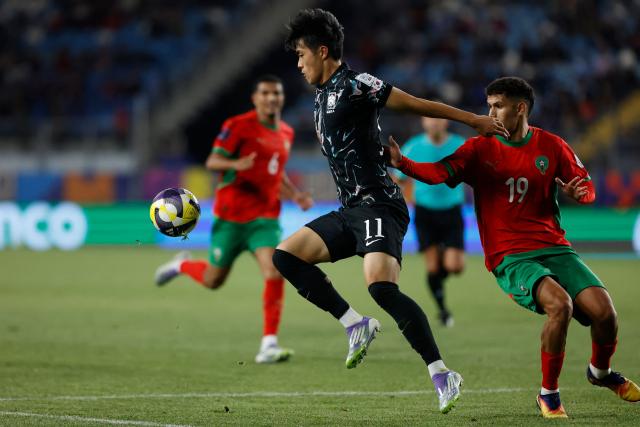 South Korea's forward #11 Myeongjun Kim and Morocco's defender #19 Smail Bakhty fight for the ball during the 2025 FIFA U-20 World Cup round of 16 football match between Morocco and South Korea at El Teniente Stadium in Rancagua, Chile on October 9, 2025. (Photo by Raul BRAVO / AFP)