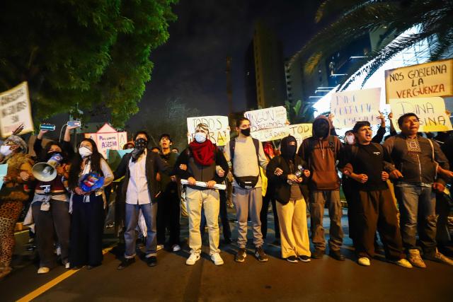 Demonstrators take part in a protest against President Dina Boluarte in front of the Ecuador embassy after the congress approved four motions of impeachment against the Peruvian in Lima on October 9, 2025. Peru's main political forces presented four motions to Congress on Thursday calling for President Dina Boluarte to be impeached in light of the severe security crisis, according to documents filed in plenary session. (Photo by Jorge CERDAN / AFP)
