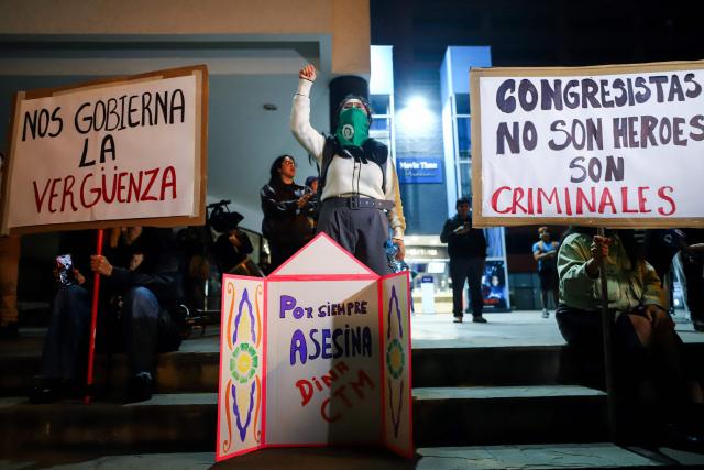 A demonstrator shouts slogans as she takes part in a protest against President Dina Boluarte in front of the Ecuador embassy after the congress approved four motions of impeachment against the Peruvian in Lima on October 9, 2025. Peru's main political forces presented four motions to Congress on Thursday calling for President Dina Boluarte to be impeached in light of the severe security crisis, according to documents filed in plenary session. (Photo by Jorge CERDAN / AFP)