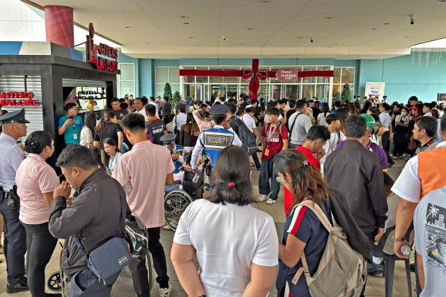 People gather outside a mall in Butuan City, on the southern island of Mindanao on October 10, 2025, after a 7.4-magnitude earthquake struck off the southern Philippines. A powerful magnitude-7.4 earthquake struck off the southern Philippines on October 10, triggering warnings of a "destructive tsunami" on the country's Pacific coast within hours. (Photo by Erwin MASCARINAS / AFP)