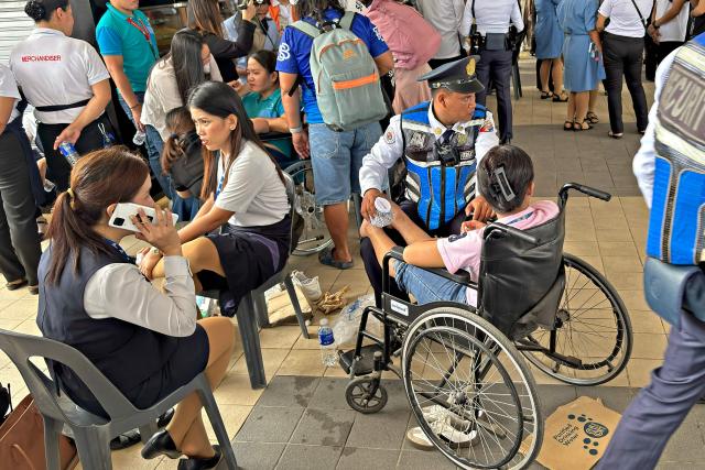 People gather outside a mall in Butuan City, on the southern island of Mindanao on October 10, 2025, after a 7.4-magnitude earthquake struck off the southern Philippines. A powerful magnitude-7.4 earthquake struck off the southern Philippines on October 10, triggering warnings of a "destructive tsunami" on the country's Pacific coast within hours. (Photo by Erwin MASCARINAS / AFP)