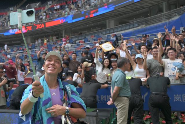 USA’s Jessica Pegula takes a photo with fans after her victory against Czech Republic’s Katerina Siniakova during their women’s singles match at the Wuhan Open tennis tournament in Wuhan, Central China’s Hubei province on October 10, 2025. (Photo by ADEK BERRY / AFP)