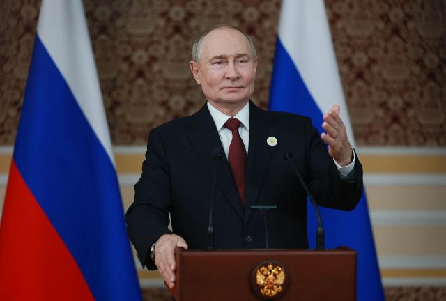 In this pool photograph distributed by the Russian state agency Sputnik, Russia's President Vladimir Putin meets with the Russian media after a meeting of the Commonwealth of Independent States (CIS) Heads of State Council in Dushanbe on October 10, 2025. (Photo by Vladimir SMIRNOV / POOL / AFP)