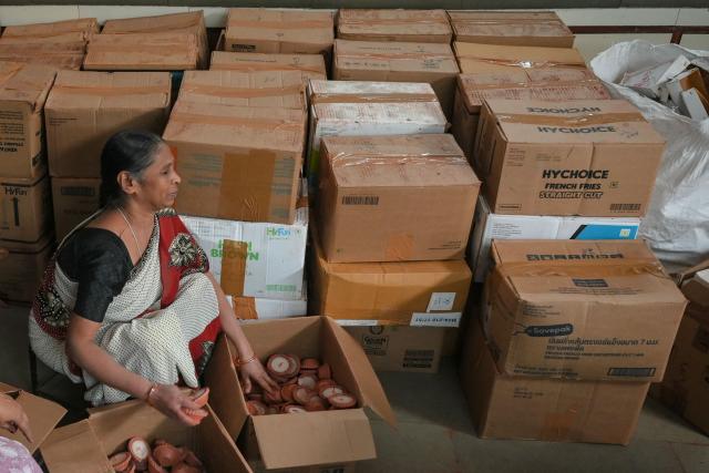 A visually impaired woman packs earthen lamps ahead of Diwali, the Hindu festival of lights, at a workshop in Ahmedabad on October 10, 2025. (Photo by Shammi MEHRA / AFP)