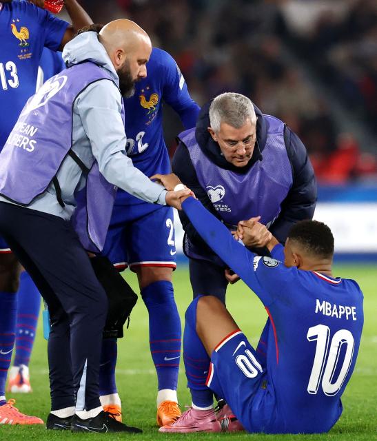 France's forward #10 Kylian Mbappe (R) is helped by France's doctor Franck Le Gall (R-top) during the FIFA World Cup 2026 Group D European qualification football match between France and Azerbaijan at the Parc des Princes Stadium in Paris on October 10, 2025. (Photo by FRANCK FIFE / AFP)