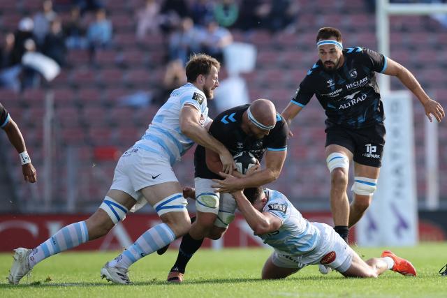 Montpellier’s Canadian lock Tyler Duguid (C) is tackled by Racing 92' English lock Jonathan Hill (L) during the French Top14 rugby union match between Racing92 and Montpellier at the Dominique Duvauchelle stadium in Creteil, on October 11, 2025. (Photo by Anne-Christine POUJOULAT / AFP)