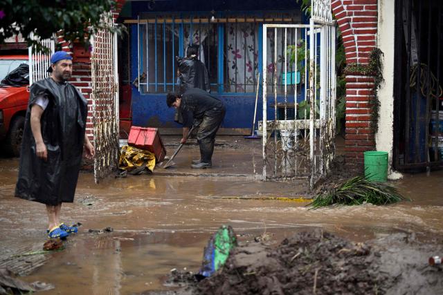 A man removes the mud on a flooded house due to the rains in the municipality of Huauchinango, Puebla State, Mexico on October 11, 2025. The death toll from heavy rains in Mexico rose to 37 on Saturday after nine more fatalities were confirmed, the Mexican government reported. (Photo by Alfredo ESTRELLA / AFP)