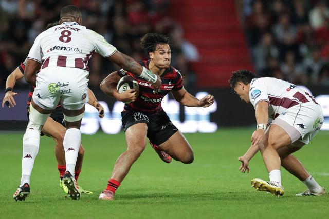 Toulouse's French centre Kalvin Gourgues (C) is tackled by Bordeaux-Begles' French lock Cameron Woki (L) during the French Top14 rugby union match between Stade Toulousain (Toulouse) and Union Bordeaux-Begles (UBB) at the Stade Ernest-Wallon in Toulouse central France, on October 12, 2025. (Photo by Valentine CHAPUIS / AFP)