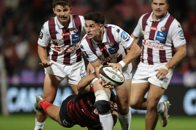Bordeaux-Begles' French fly-half Joseph Carbery (C) is tackled during the French Top14 rugby union match between Stade Toulousain (Toulouse) and Union Bordeaux-Begles (UBB) at the Stade Ernest-Wallon in Toulouse central France, on October 12, 2025. (Photo by Valentine CHAPUIS / AFP)