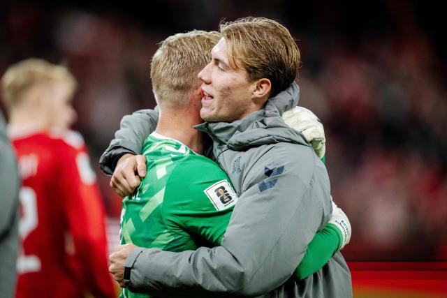 Denmark's goalkeeper Kasper Schmeichel (L) and Denmark's Rasmus Hoejlund hug each other after winning the FIFA World Cup 2026 Group C European qualification football match between Denmark and Greece at the Parken Stadium in Copenhagen on October 12, 2025. (Photo by Mads Claus Rasmussen / Ritzau Scanpix / AFP) / Denmark OUT