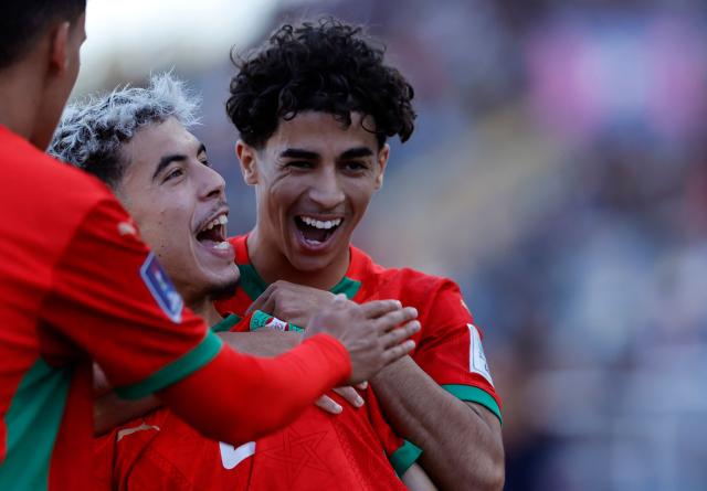 Morocco's forward #21 Yassir Zabiri (c) celebrates with teammates after an own goal scored by United States' defender #04 Joshua Wynder (out of frame) during the 2025 FIFA U-20 World Cup quarter-final football match between United States and Morocco at the El Teniente Stadium in Rancagua, Chile on October 12, 2025. (Photo by Raul BRAVO / AFP)