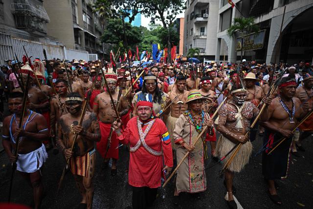 Supporters of the Venezuelan government take part in a march to commemorate the "Day of Indigenous Resistance" in Caracas on October 12, 2025. On Sunday, Venezuelan President Nicolбs Maduro called opposition leader Marнa Corina Machado a “demonic witch,” two days after she was awarded the Nobel Peace Prize. (Photo by Federico PARRA / AFP)