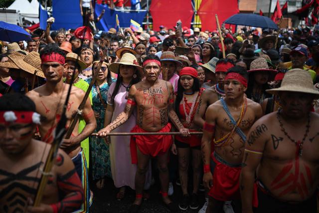 Supporters of the Venezuelan government take part in a march to commemorate the "Day of Indigenous Resistance" in Caracas on October 12, 2025. On Sunday, Venezuelan President Nicolбs Maduro called opposition leader Marнa Corina Machado a “demonic witch,” two days after she was awarded the Nobel Peace Prize. (Photo by Federico PARRA / AFP)