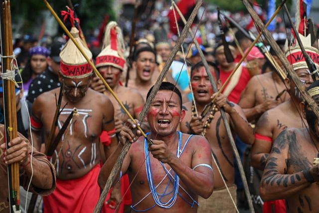 Venezuelan indigenous men take part in a march to commemorate the "Day of Indigenous Resistance" in Caracas on October 12, 2025. On Sunday, Venezuelan President Nicolбs Maduro called opposition leader Marнa Corina Machado a “demonic witch,” two days after she was awarded the Nobel Peace Prize. (Photo by Federico PARRA / AFP)