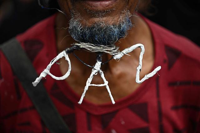 A supporter of Venezuela's President Nicolas Maduro sports a decorated beard during a march to commemorate the "Day of Indigenous Resistance" in Caracas on October 12, 2025. On Sunday, Venezuelan President Nicolбs Maduro called opposition leader Marнa Corina Machado a “demonic witch,” two days after she was awarded the Nobel Peace Prize. (Photo by Federico PARRA / AFP)
