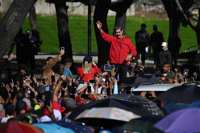 Venezuela's President Nicolas Maduro waves to supporters during a march to commemorate the "Day of Indigenous Resistance" in Caracas on October 12, 2025. On Sunday, Venezuelan President Nicolбs Maduro called opposition leader Marнa Corina Machado a “demonic witch,” two days after she was awarded the Nobel Peace Prize. (Photo by Federico PARRA / AFP)
