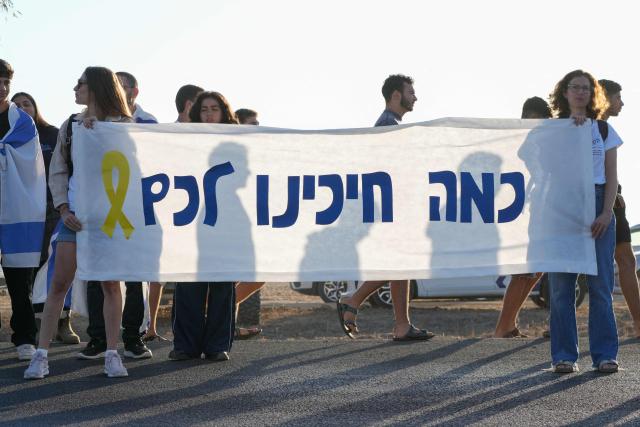 Israelis gather to show support for hostages about to arrive in the Reim military base in southern Israel from Gaza on October 13, 2025. Hebrew writing on banner reads: "How good it is that youre coming home". Hamas was set to release all surviving hostages on on October 13 in exchange for Palestinian prisoners held by Israel, as US President Donald Trump headed to the region for a peace summit having declared the war "over". Trump's lightning visit to Israel and Egypt aims to celebrate his role in brokering last week's ceasefire and hostage release deal -- but comes at a precarious time as Israel and Hamas negotiate what comes next. (Photo by MAYA LEVIN / AFP)