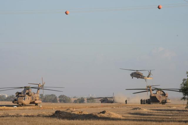 Israeli military helicopters wait in preparation to take hostages released by Hamas in Gaza to hospitals in Israel after they arrive in the southern Reim army base on October 13, 2025. Hamas was set to release all surviving Israeli hostages on October 13 in exchange for Palestinian prisoners held by Israel, as US President Donald Trump headed to the region for a peace summit having declared the war "over". Trump's lightning visit to Israel and Egypt aims to celebrate his role in brokering last week's ceasefire and hostage release deal -- but comes at a precarious time as Israel and Hamas negotiate what comes next. (Photo by MAYA LEVIN / AFP)