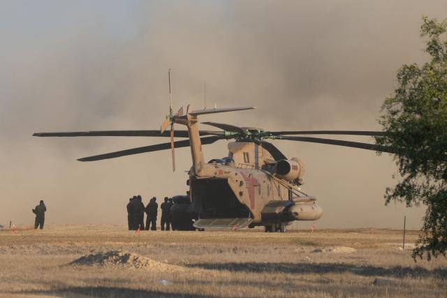 An Israeli military helicopter waits in preparation to take hostages released by Hamas in Gaza to hospitals in Israel after they arrive in the southern Reim army base on October 13, 2025. Hamas was set to release all surviving Israeli hostages on October 13 in exchange for Palestinian prisoners held by Israel, as US President Donald Trump headed to the region for a peace summit having declared the war "over". Trump's lightning visit to Israel and Egypt aims to celebrate his role in brokering last week's ceasefire and hostage release deal -- but comes at a precarious time as Israel and Hamas negotiate what comes next. (Photo by MAYA LEVIN / AFP)