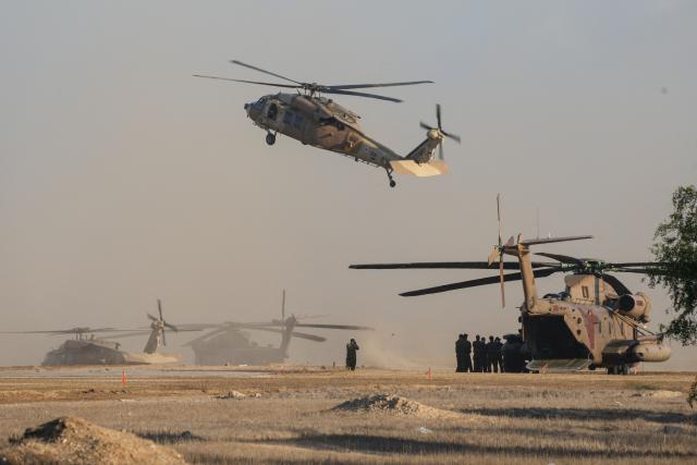 Israeli military helicopters wait in preparation to take hostages released by Hamas in Gaza to hospitals in Israel after they arrive in the southern Reim army base on October 13, 2025. Hamas was set to release all surviving Israeli hostages on October 13 in exchange for Palestinian prisoners held by Israel, as US President Donald Trump headed to the region for a peace summit having declared the war "over". Trump's lightning visit to Israel and Egypt aims to celebrate his role in brokering last week's ceasefire and hostage release deal -- but comes at a precarious time as Israel and Hamas negotiate what comes next. (Photo by MAYA LEVIN / AFP)