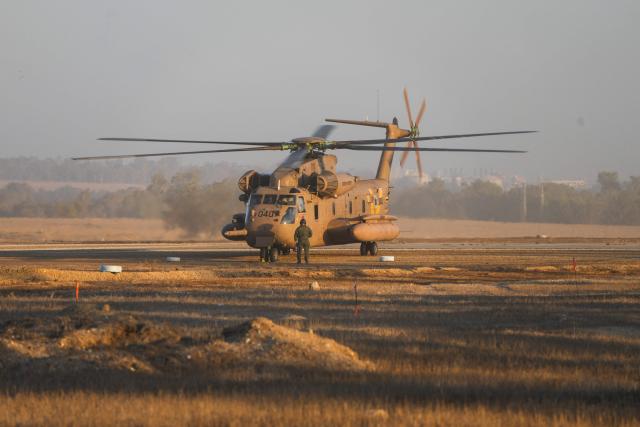 An Israeli military helicopter waits in preparation to take hostages released by Hamas in Gaza to hospitals in Israel after they arrive in the southern Reim army base on October 13, 2025. Hamas was set to release all surviving Israeli hostages on October 13 in exchange for Palestinian prisoners held by Israel, as US President Donald Trump headed to the region for a peace summit having declared the war "over". Trump's lightning visit to Israel and Egypt aims to celebrate his role in brokering last week's ceasefire and hostage release deal -- but comes at a precarious time as Israel and Hamas negotiate what comes next. (Photo by MAYA LEVIN / AFP)