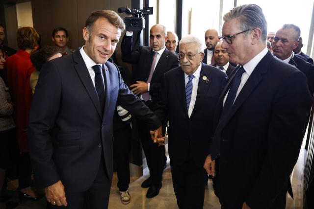 Palestinian president Mahmud Abbas (C) speaks with Britain's Prime Minister Keir Starmer (R) and France's President Emmanuel Macron (L) upon arrival at the congress centre to attend the Sharm El-Sheikh Peace Summit, in the Egyptian Red Sea resort town of Sharm el-Sheikh, on October 13, 2025. Trump and Sisi will chair the Gaza summit of more than 20 world leaders on October 13, 2025 in Egypt's Sharm El-Sheikh. Among those expected to attend are UN Secretary-General Antonio Guterres, Jordan's King Abdullah II, Britain's Prime Minister Keir Starmer, France's President Emmanuel Macron and his Turkey's counterpart Recep Tayyip Erdogan. Canada will also be represented by its Prime Minister Mark Carney. (Photo by Yoan VALAT / POOL / AFP)