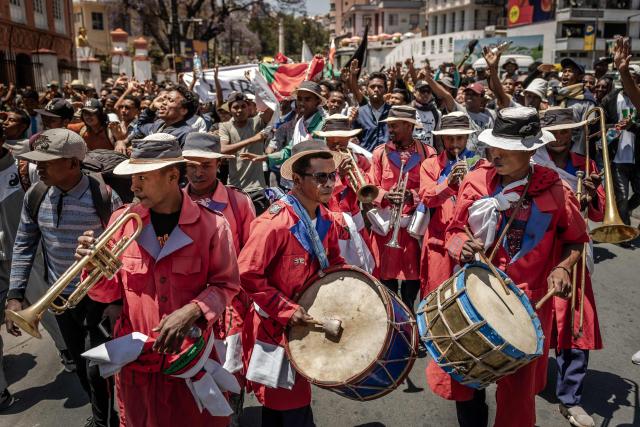 Members of a band play music as students dance and march in celebration toward a civil society rally in Antananarivo, on October 13, 2025. Soldiers and security forces joined hundreds celebrating in Madagascar's capital on October 13, 2025, hours before President Andry Rajoelina was due to address the nation following weeks of protests and growing calls for his resignation. (Photo by Luis TATO / AFP)