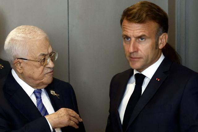 France's President Emmanuel Macron (R) and Palestinian president Mahmud Abbas (2nd R) leave after their meeting on the sideline of Sharm El-Sheikh Peace Summit, in the Egyptian Red Sea resort town of Sharm el-Sheikh, on October 13, 2025. The summit, co-chaired by US President Donald Trump and Egypt's Abdel Fattah al-Sisi, will see more than 20 leaders gather to mark the Gaza ceasefire and the return of Israeli hostages in exchange for Palestinian detainees. (Photo by Yoan VALAT / POOL / AFP)