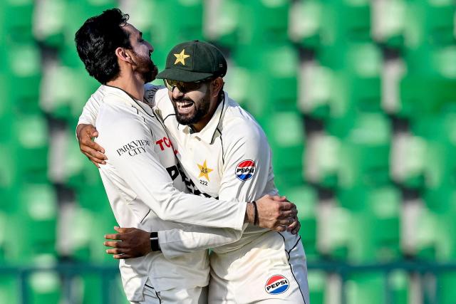 Pakistan's Salman Agha (L) celebrates with Babar Azam after taking the wicket of South Africa's Ryan Rickelton during the second day of the first Test cricket match between Pakistan and South Africa at the Gaddafi Stadium in Lahore on October 13, 2025. (Photo by Aamir QURESHI / AFP)