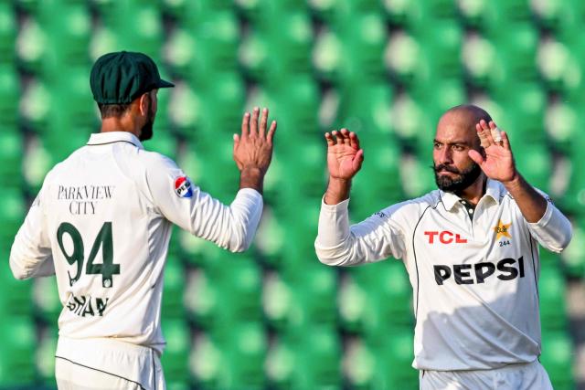 Pakistan's Sajid Khan (R) celebrates with captain Shan Masood after taking the wicket of South Africa's Dewald Brevis during the second day of the first Test cricket match between Pakistan and South Africa at the Gaddafi Stadium in Lahore on October 13, 2025. (Photo by Aamir QURESHI / AFP)