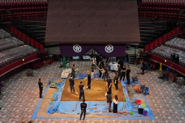 Members of the crew construct the dohyo, the ring, made from clay and sand, as preparations are underway inside the Royal Albert Hall in central London on October 13, 2025, ahead of the Grand Sumo Tournament being held over five days in London from October 15th. Over 40 of Japan’s elite maku-uchi rikishi (wrestlers) will compete in London this week, bringing with them the 1,500-year legacy of Sumo, 34 years after the venue last hosted the Tournament. (Photo by CARLOS JASSO / AFP)