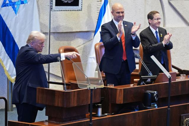US President Donald Trump (L) gestures as Speaker Amir Ohana and Israel's President Isaac Herzog applause at the Israeli parliament, the Knesset, in Jerusalem on October 13, 2025. Hamas handed over the 20 surviving Israeli hostages on October 13 under a ceasefire agreement, as the US president and other world leaders geared up for a summit on Gaza. The releases are part of a ceasefire agreement brokered by the US president, with Israel due in return to free nearly 2,000 detainees held in its jails in exchange. (Photo by Evan Vucci / POOL / AFP)