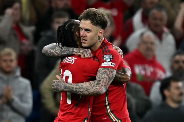 Wales' defender Joe Rodon (R) celebrates scoring the team's first goal during the 2026 World Cup Group J qualifier football match between Wales and Belgium, at Cardiff City Stadium, in Cardiff, on October 13, 2025. (Photo by Paul ELLIS / AFP)