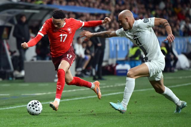#17 Switzerland's midfielder Ruben Vargas (L) fights for the ball with #21 Slovenia's defender Vanja Drkusic during the 2026 World Cup qualifiers Europe zone group B football match between Slovenia and Switzerland at Stadion Stozice in Ljubljana, on October 13, 2025.  (Photo by Jure Makovec / AFP)