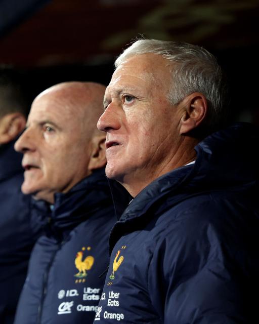 France's head coach Didier Deschamps (R) and team members stand for the national anthem prior to the 2026 World Cup qualifying round Group D football match between Iceland and France at the Laugardalsvollur Stadium in Reykjavik on October 13, 2025. (Photo by Franck FIFE / AFP)