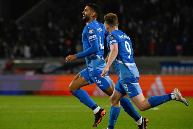 Iceland's defender #04 Victor Palsson (L) celebrates scoring the opening goal with his teammate Iceland's midfielder #09 Saevar Atli Magnusson during the 2026 World Cup qualifying round Group D football match between Iceland and France at the Laugardalsvollur Stadium in Reykjavik on October 13, 2025. (Photo by Halldor KOLBEINS / AFP)