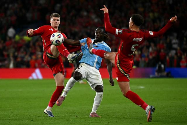Wales' midfielder Jordan James (L) and Wales' defender Ethan Ampadu (R) battle for the ball with Belgium's striker #11 Jeremy Doku during the 2026 World Cup Group J qualifier football match between Wales and Belgium, at Cardiff City Stadium, in Cardiff, on October 13, 2025. (Photo by Paul ELLIS / AFP)