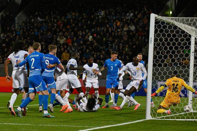France's goalkeeper #16 Mike Maignan (R) fails to save the opening goal during the 2026 World Cup qualifying round Group D football match between Iceland and France at the Laugardalsvollur Stadium in Reykjavik on October 13, 2025. (Photo by Halldor KOLBEINS / AFP)