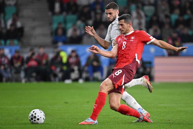 #15 Slovenia's forward Danijel Sturm (L) fights for the ball with #08 Switzerland's midfielder Remo Freuler during the 2026 World Cup qualifiers Europe zone group B football match between Slovenia and Switzerland at Stadion Stozice in Ljubljana, on October 13, 2025.  (Photo by Jure Makovec / AFP)