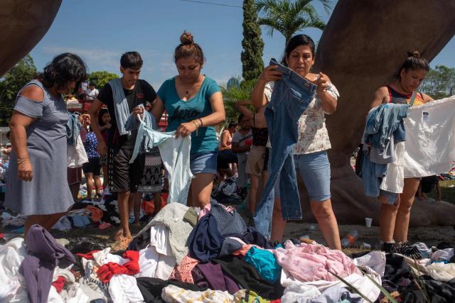 Flood victims sort through donated clothing after severe flooding hit the city of Alamo, in Veracruz state, Mexico, on October 13, 2025. The death toll from flooding in central and eastern Mexico -mostly in the Veracruz, Hidalgo and Puebla states- has risen sharply to at least 64, with another 65 still missing, authorities reported. (Photo by Hector  Quintanar / AFP)