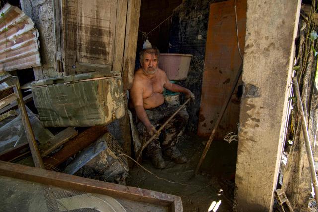 A resident sits amid debris after severe flooding hit the town of Alamo, in Veracruz state, Mexico, on October 13, 2025. At least 64 people have died and 65 remain missing in Mexico following heavy rains that caused flooding and left a trail of destruction in the worst-affected states of Hidalgo, Puebla, Queretaro and Veracruz, the government announced. (Photo by Marco Antonio Perez / AFP)