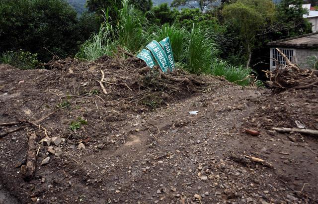 A road sign lies on the ground after a landslide hit the Tenango de Doria–San Bartolo Tutotepec road in Hidalgo state, Mexico, on October 13, 2025. The death toll from flooding in central and eastern Mexico -mostly in the Veracruz, Hidalgo and Puebla states- has risen sharply to at least 64, with another 65 still missing, authorities reported. (Photo by Alfredo ESTRELLA / AFP)