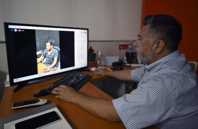 Rene Martinez, director of Radio Universidad San Bartolo at the Autonomous University of the State of Hidalgo, checks the transmission of messages and information to residents affected by recent rains in communities surrounding San Bartolo Tutotepec, Hidalgo state, Mexico, on October 13, 2025. The death toll from flooding in central and eastern Mexico -mostly in the Veracruz, Hidalgo and Puebla states- has risen sharply to at least 64, with another 65 still missing, authorities reported. (Photo by Alfredo ESTRELLA / AFP)